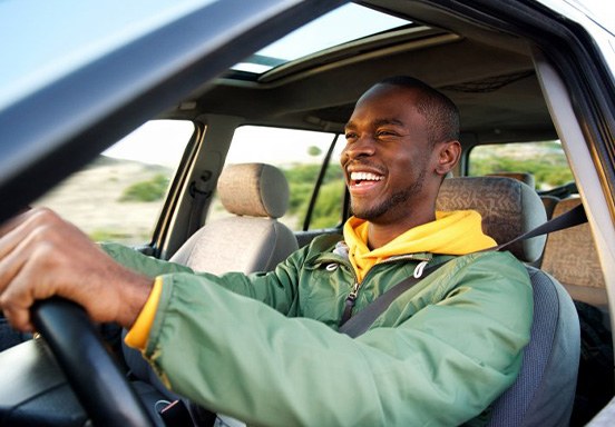Man smiles while driving