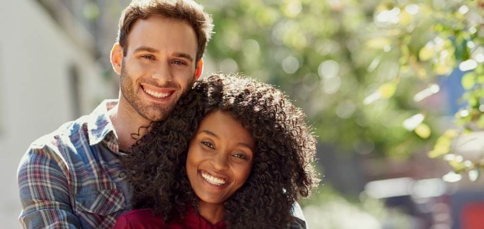 Man and woman hugging and smiling outdoors