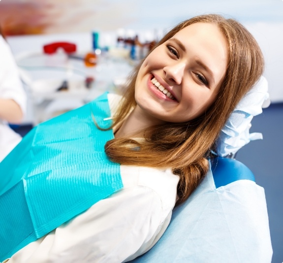 Smiling young woman leaning back in dental chair