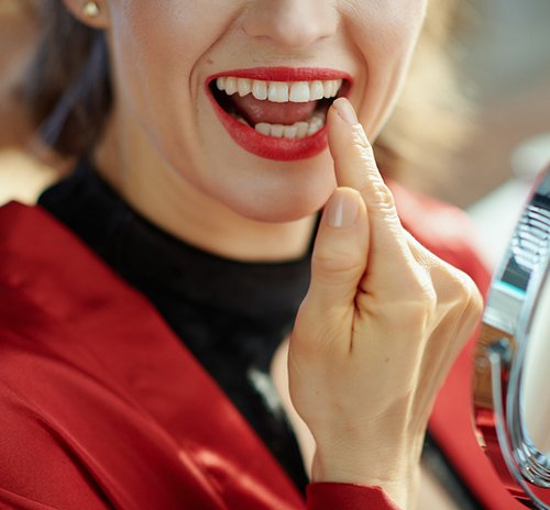 a person checking their teeth with a mirror