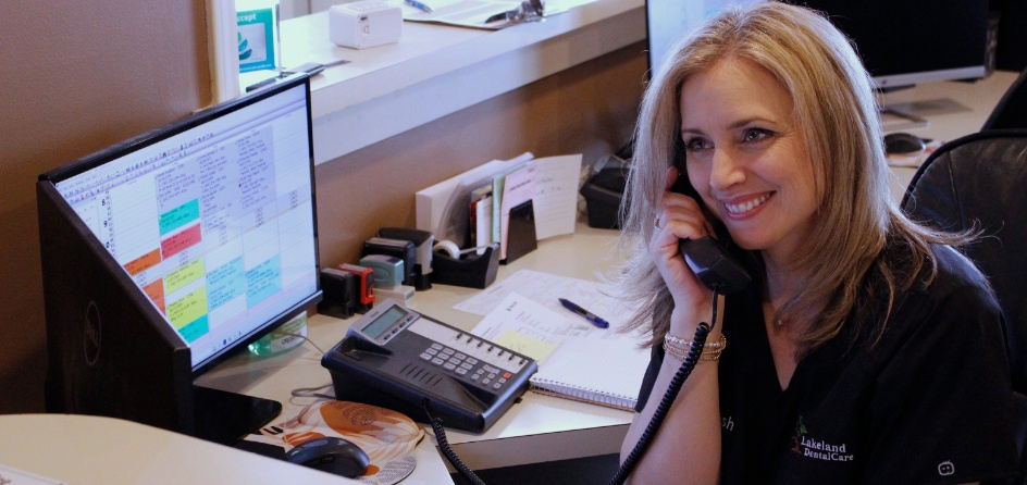 Smiling dental team member answering phone in Jackson dental office