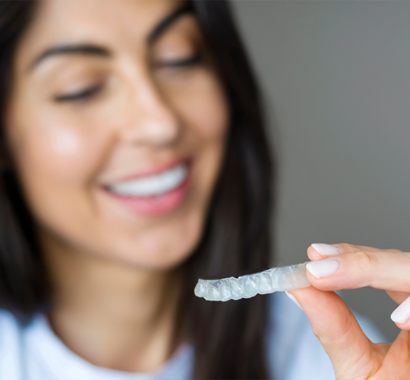 Woman using an at home teeth whitening kit