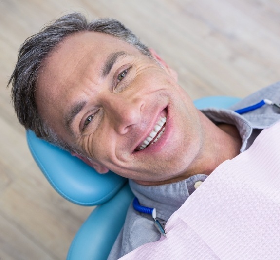 Smiling man laying back in dental chair