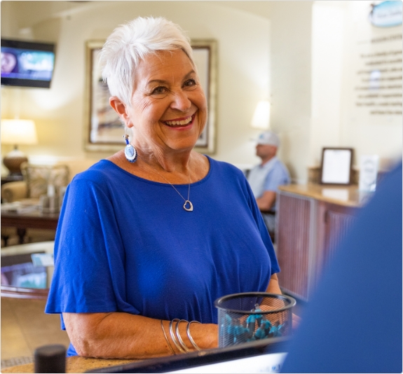 Smiling woman standing in reception area of Jackson dental office