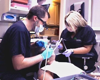 Dentist and assistant treating a dental patient