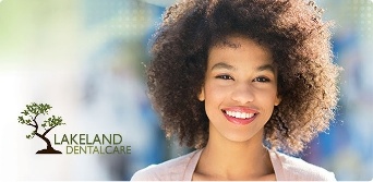 Smiling woman next to Lakeland Dental Care logo
