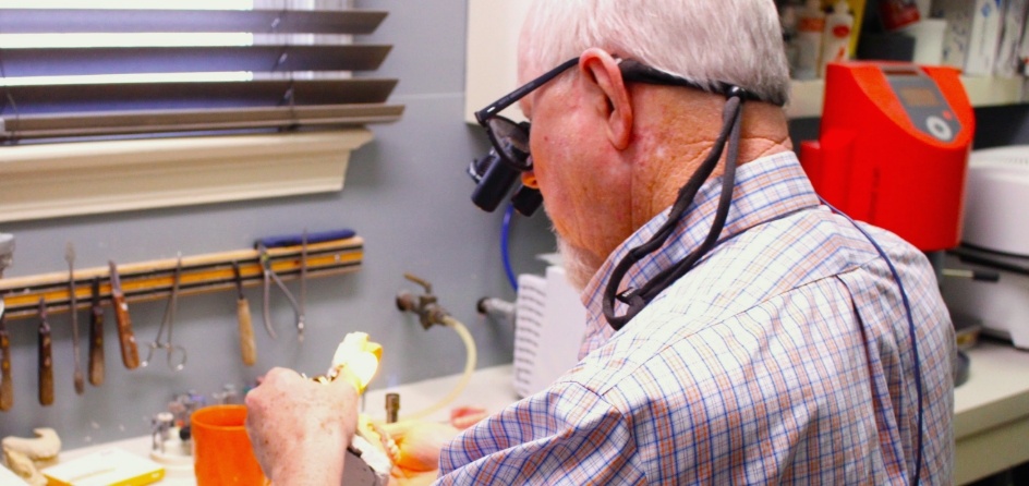  Jackson Mississippi dentist Doctor Alex Abernathy looking at model of teeth