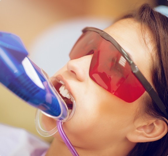 Girl in dental chair with fluoride trays on her teeth