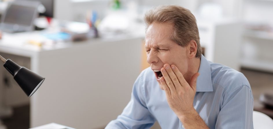 Man holding his jaw in pain before T M J treatment in Jackson