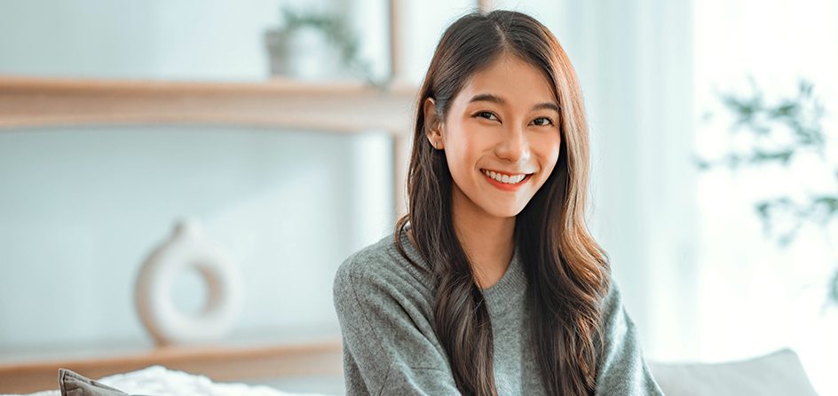 Smiling woman sitting on couch at home