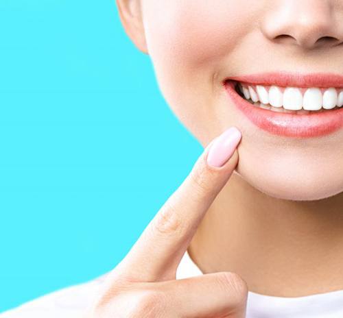 Close up of woman’s smile on a bright blue background