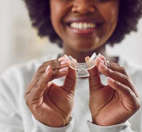 Woman holding a teeth whitening tray